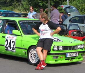 Bloke with a mullet leaning against vomit-green tuned BMW